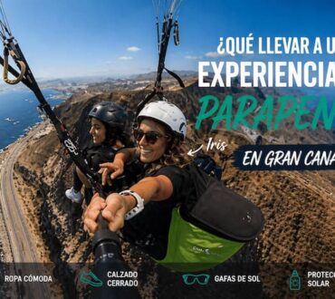 Piloto de parapente biplaza, Iris, volando con una pasajera sobre acantilados y costa de Gran Canaria en un día despejado.